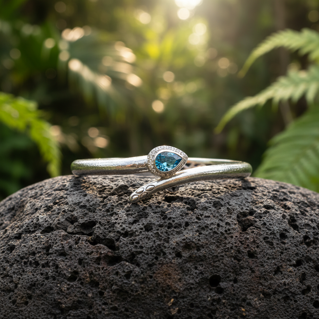 Bangle Black Mamba posato su pietra lavica in un giardino tropicale balinese, argento 925 con topazio blu sky e pavé zirconi bianchi – Balinesia
