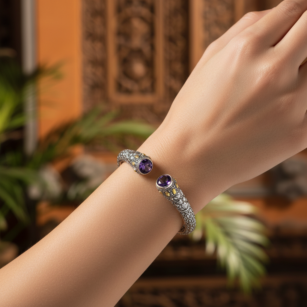 Bangle Naga Ametista in argento 925 ossidato indossato al polso, sfondo balinese in legno intagliato, due ametiste ovali viola con accenti oro 18K – Balinesia
