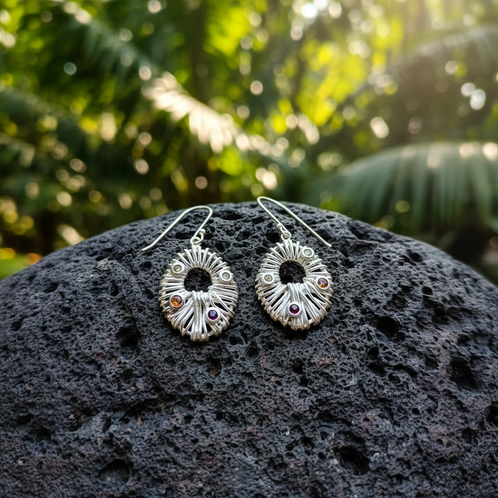 Orecchini Surya Bali Balinesia su pietra vulcanica con forma ovale in argento 925 lavorata a raggi, pietre naturali peridoto verde, citrino arancio e granato rosso incastonate a mano, gancio ear-wire visibile