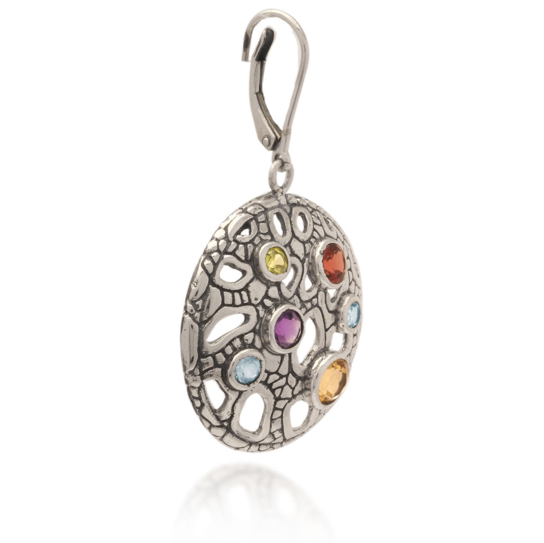 Orecchini Naga Multigemme Balinesia su sfondo bianco, singolo orecchino vista laterale – profilo curvilineo del disco traforato in argento 925 ossidato con pietre naturali multicolore – chiusura leverback – Collezione Sisik Naga