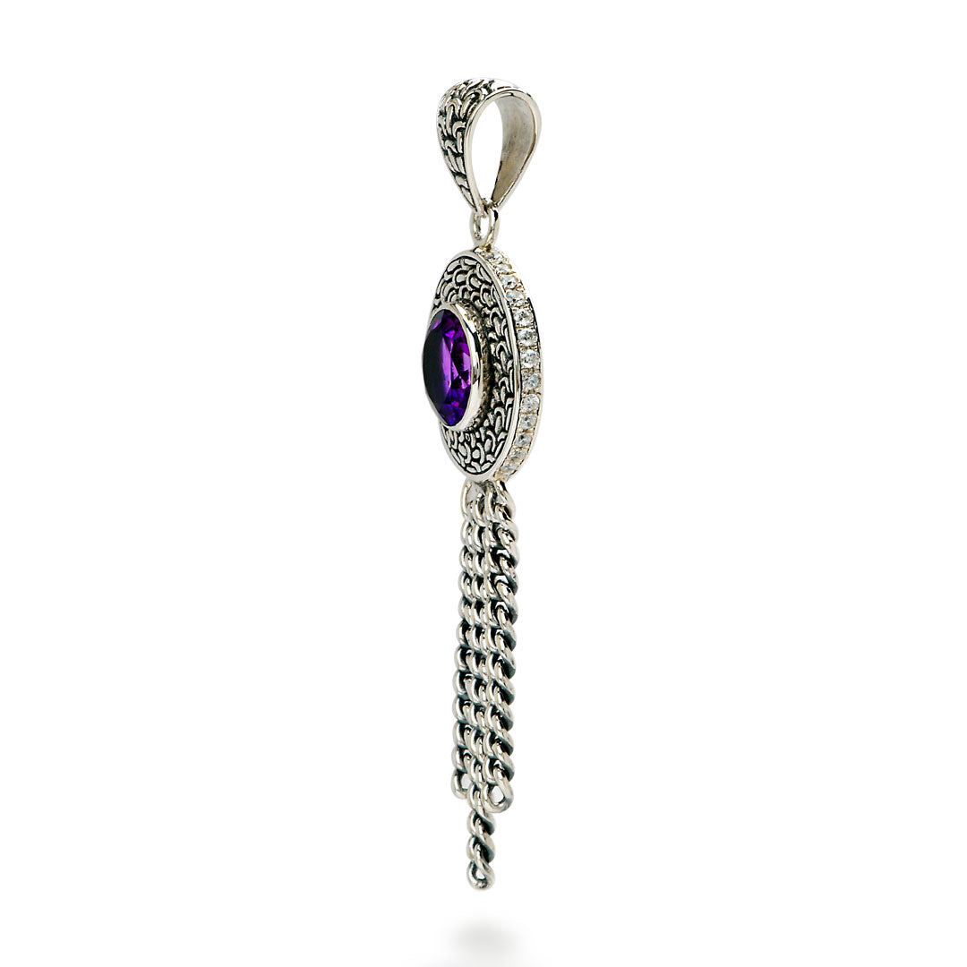 Ciondolo Sisik Naga Ametista Balinesia, vista laterale su sfondo bianco con corpo circolare a volute in argento 925 ossidato, ametista viola e nappa di catene curb
