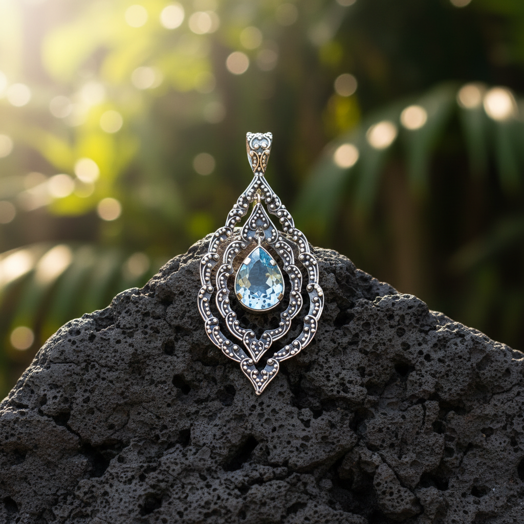 Ciondolo Mandala Topazio in argento 925 della Collezione Essenza di Ubud Balinesia, su roccia lavica con sfondo verde tropicale