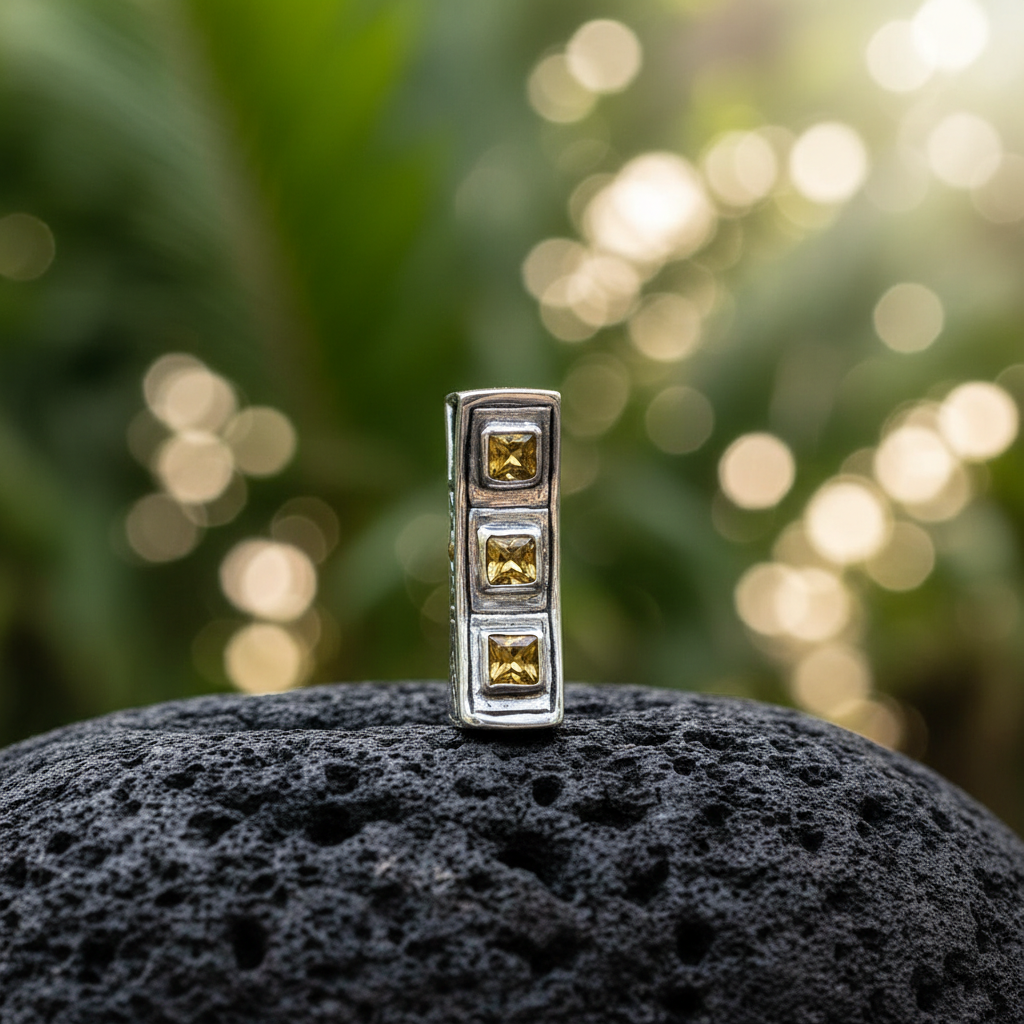 Ciondolo Sinar Citrino Balinesia su roccia vulcanica nera con sfondo giungla tropicale bokeh e luce dorata, tre citrini quadrati in colonna in argento 925 ossidato