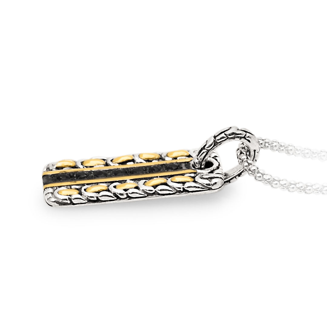 Ciondolo Naga Noir Balinesia indossato su modella con abito bianco a scollatura V, sfondo bambù con luce naturale, pendente rettangolare in argento 925 ossidato con zaffiri neri