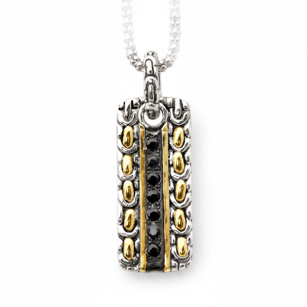 Ciondolo Naga Noir Balinesia su roccia vulcanica nera con sfondo giungla tropicale bokeh e luce dorata, zaffiri neri naturali e strisce in oro 18k in primo piano