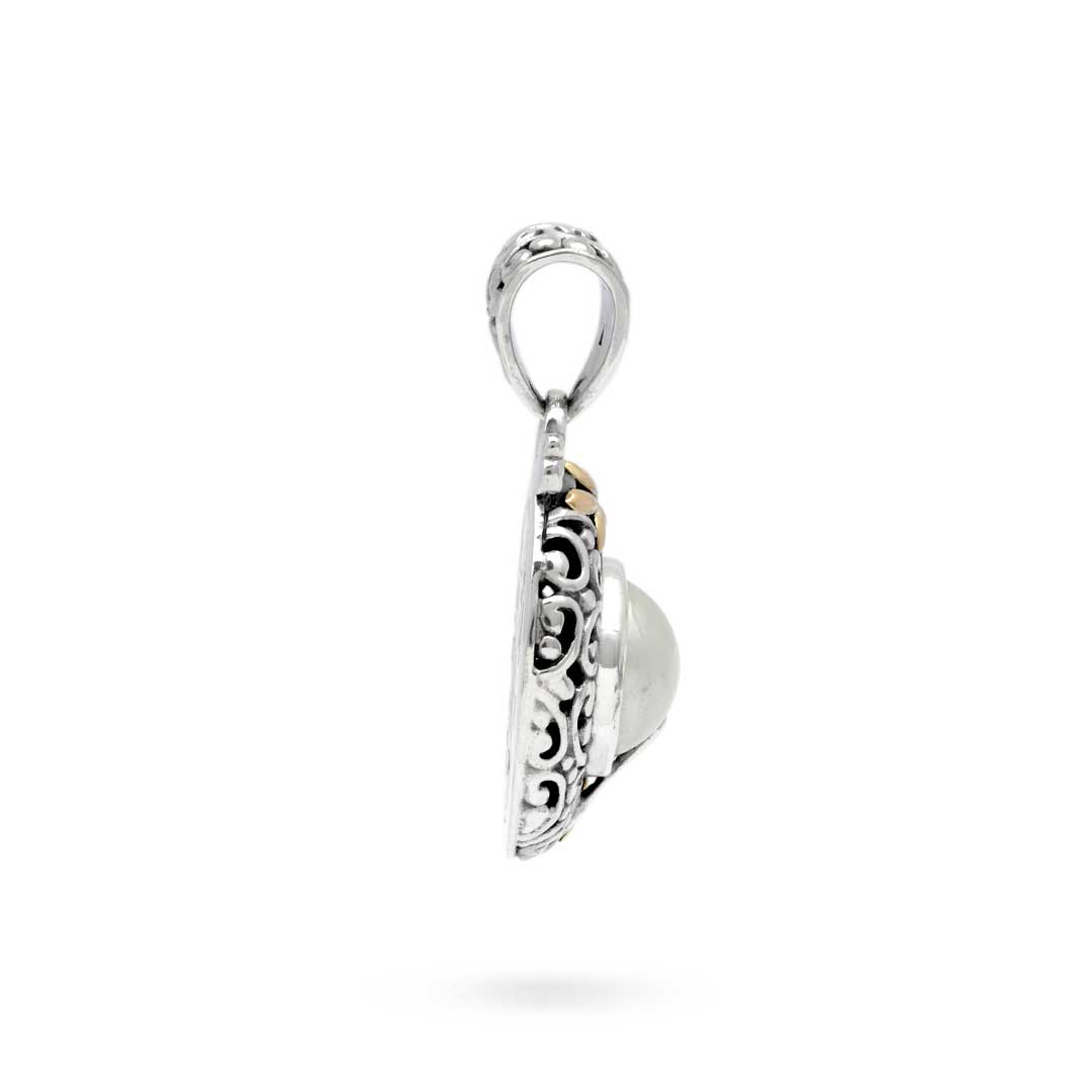 Ciondolo Lovina Balinesia, vista 3/4 su sfondo bianco con fiorellino in oro 18k in basso, volute laterali traforatein argento 925 ossidato e gancio traforato