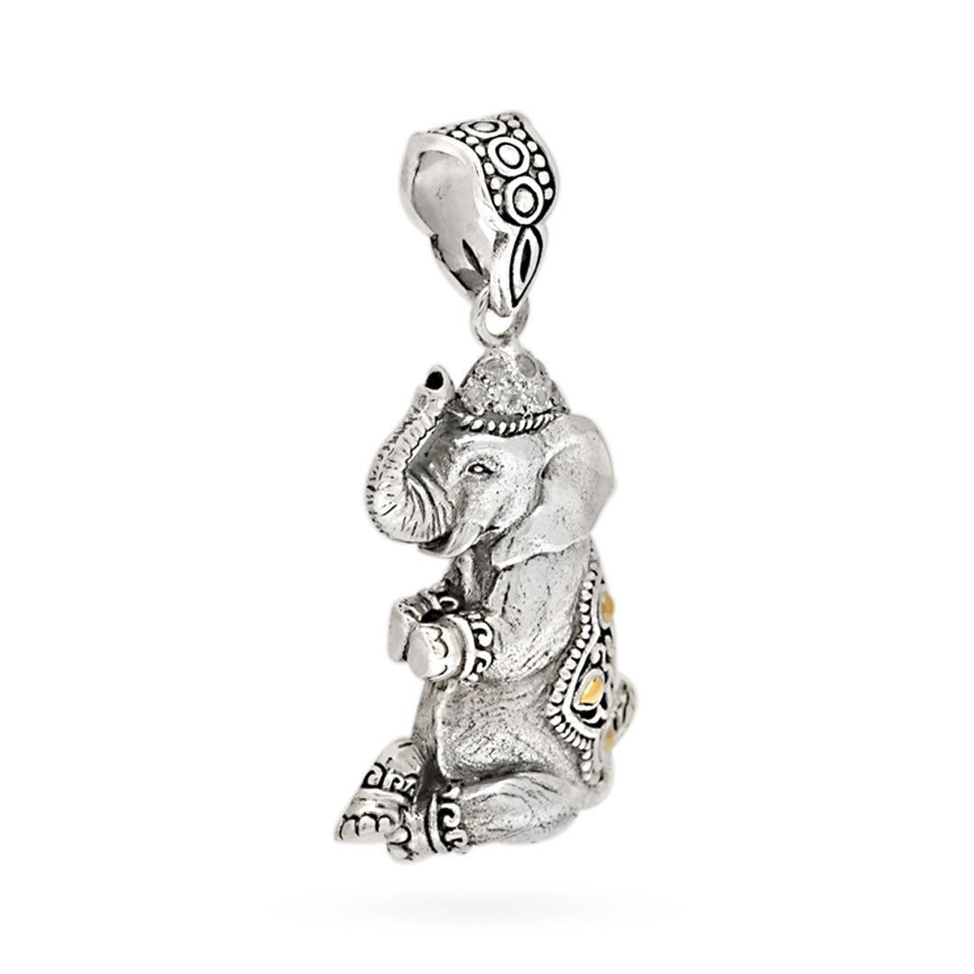 Ciondolo Gajah Balinesia, vista laterale sinistra su sfondo bianco con profilo dell’elefante in argento 925 ossidato, gualdrappa decorata con motivi a volute e dettagli in oro 18k