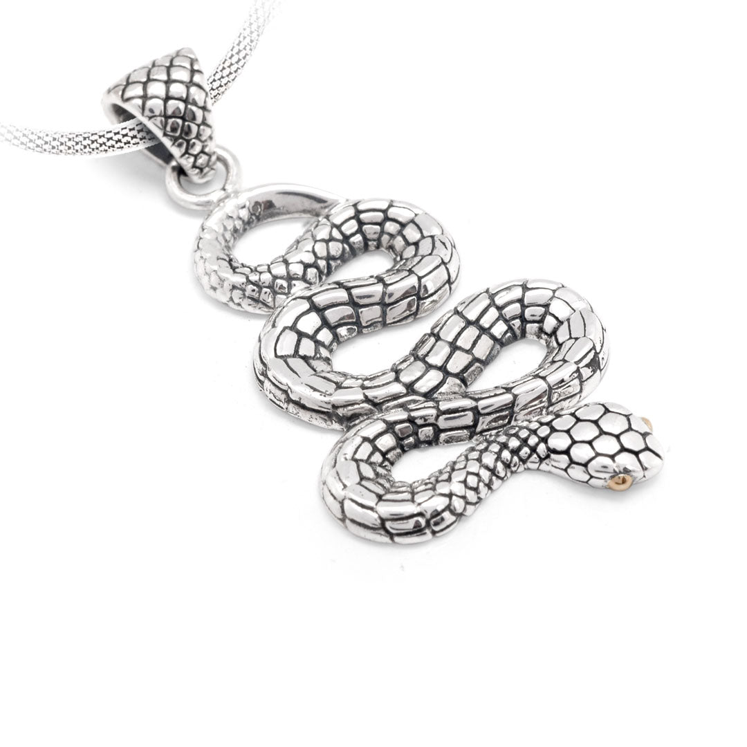 Ciondolo Ular Balinesia, vista 3/4 ravvicinata su sfondo bianco con dettaglio testa del serpente in argento 925 ossidato, occhi in oro 18k, lingua biforcuta e scaglie esagonali sul ventre