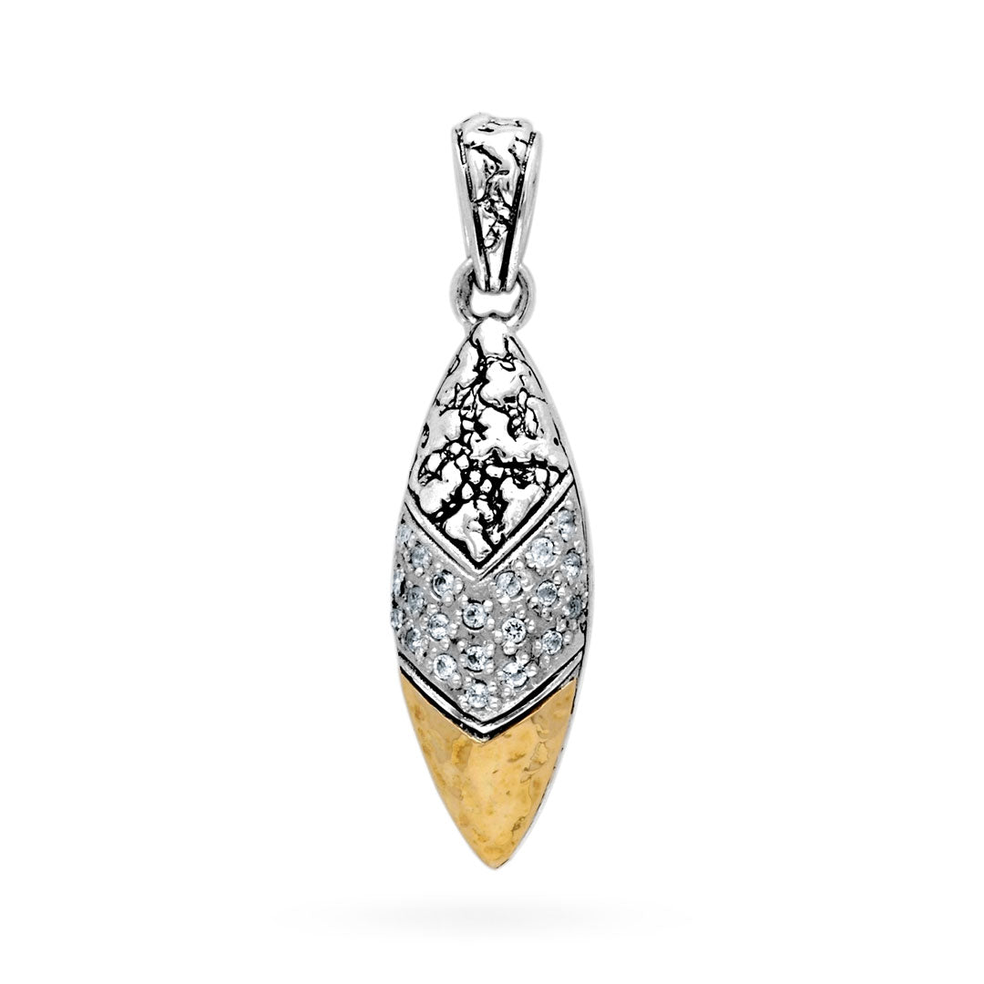 Ciondolo Daun Gunung Balinesia indossato su modella con abito bianco a scollatura V, sfondo porta intagliata balinese con luce calda, pendente a navetta in argento 925 ossidato con topazi bianchi e punta oro
