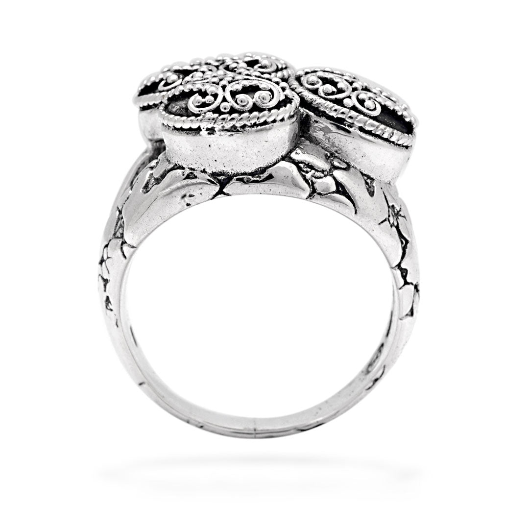 Anello Jawan Balinesia, vista tre quarti su sfondo bianco, dettaglio medaglioni con volute granulate e fascia craquelé ossidato