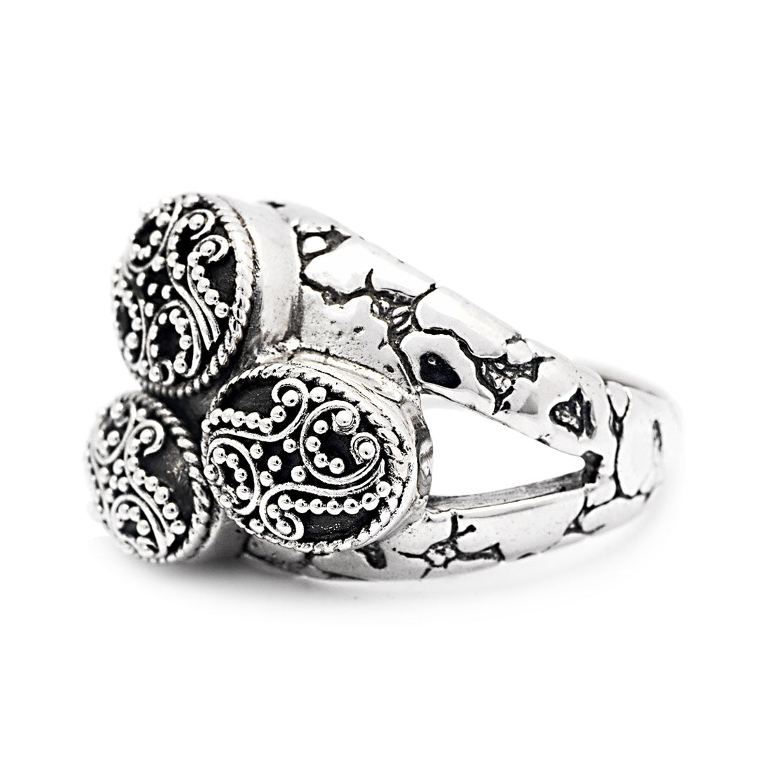 Anello Jawan Balinesia, vista laterale profilo su sfondo bianco, struttura aperta con testa a grappolo e fascia ossidato in evidenza