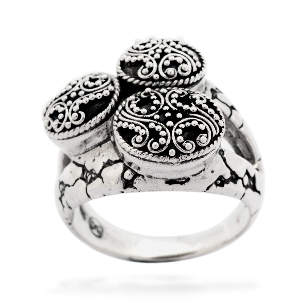 Anello Jawan Collezione Gunung Agung, vista tre quarti angolata su sfondo bianco, profilo bombato dei medaglioni e texture craquelé sulla fascia
