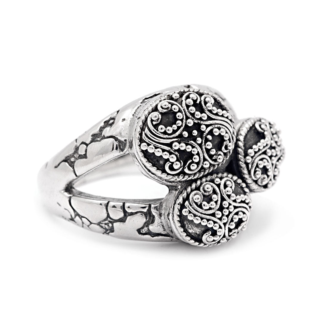 Anello Jawan Collezione Gunung Agung, vista laterale tre quarti su sfondo bianco, dettaglio fascia craquelé e bordo a treccia granulata dei medaglioni