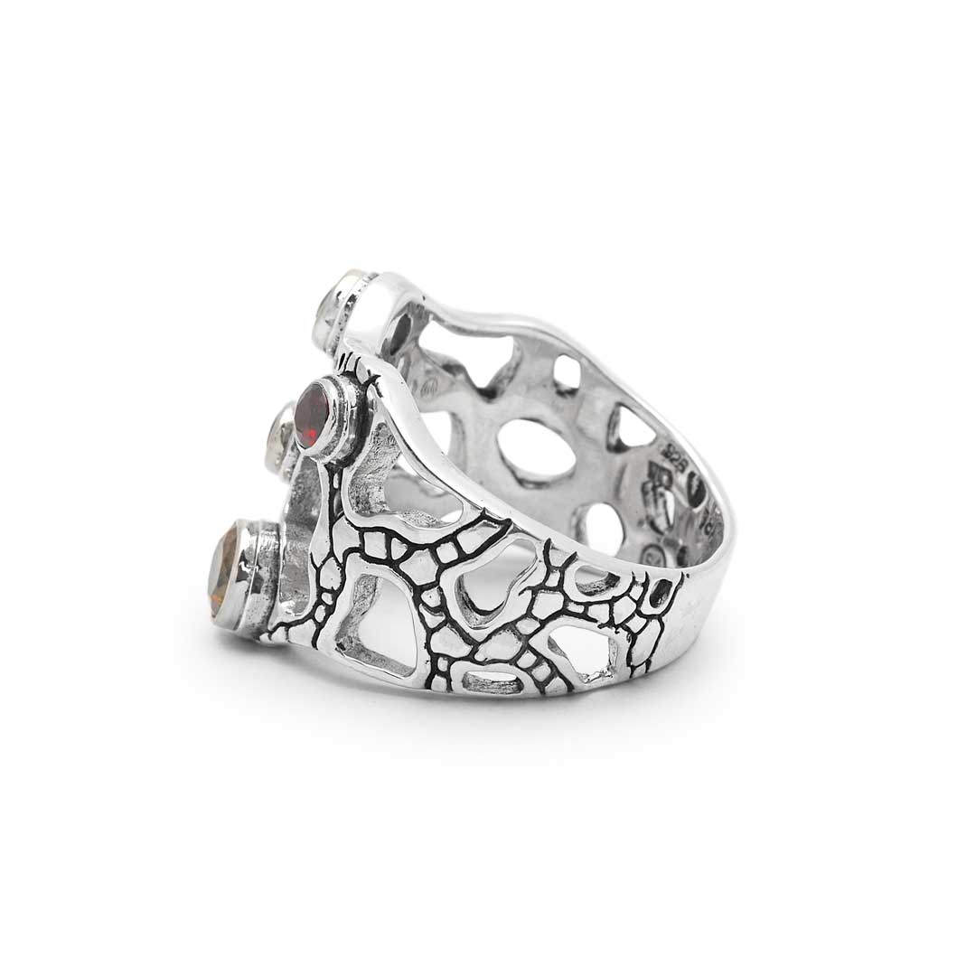 Anello Naga Balinesia, vista tre quarti angolata, dettaglio texture craquelé ossidato e incastonatura a castone delle pietre