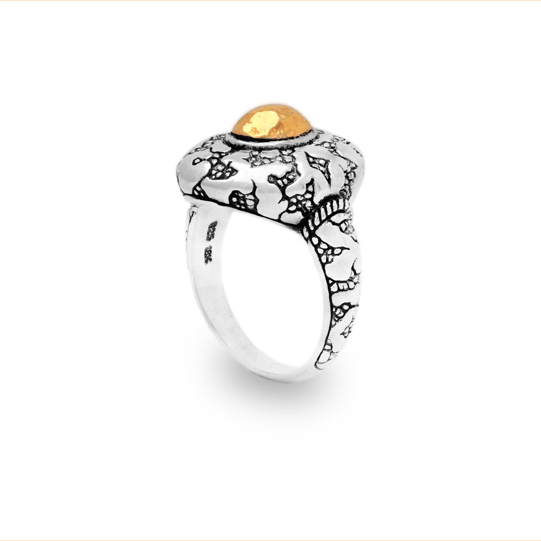 Anello Batu Api Balinesia, vista frontale su sfondo bianco, fascia larga bombata con texture craquelé e castone oro 18K in evidenza