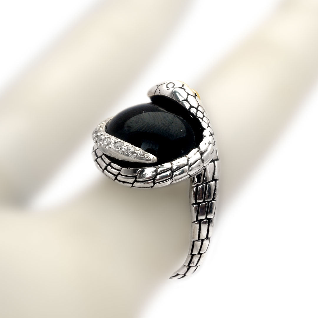 Anello Cobra Onyx Balinesia indossato su dito, vista zenitale su sfondo avorio, grande cabochon di onice nera con fila di white topaz naturali lungo il corpo serpente in argento 925