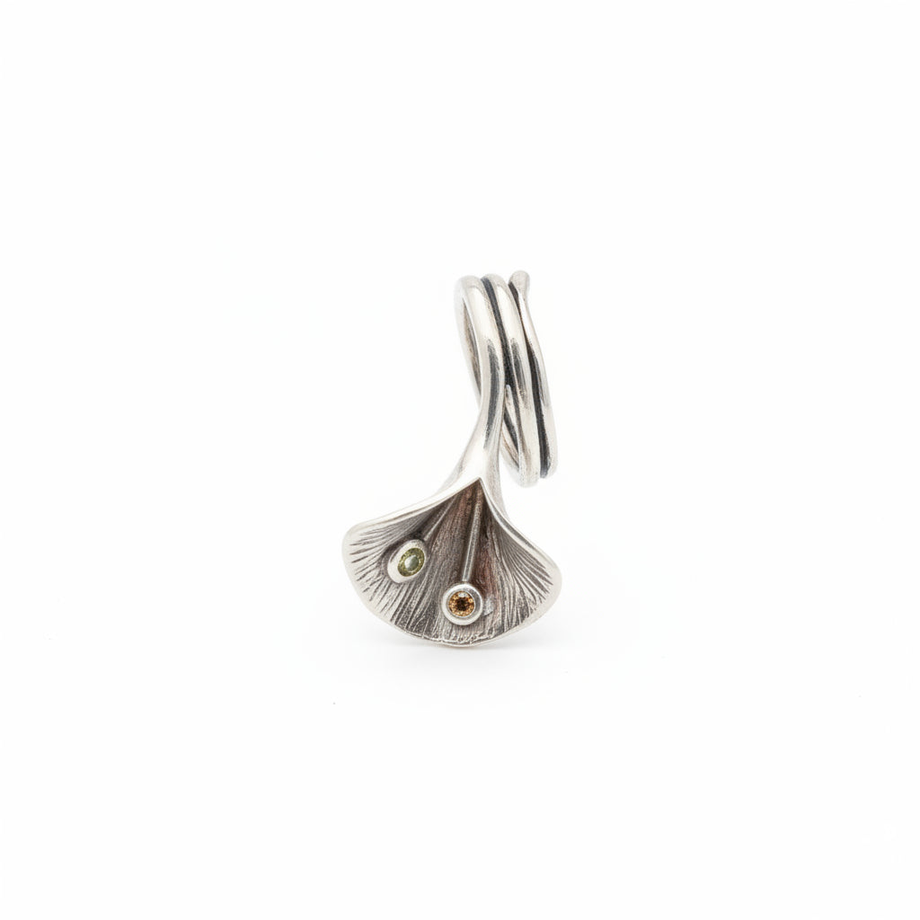 Anello Foglia di Ginkgo Balinesia, vista laterale su sfondo bianco con foglia di ginkgo in argento 925 ossidato, pietre peridoto verde e granato arancio in evidenza, banda a tre fili aperta, Collezione Essenza di Ubud
