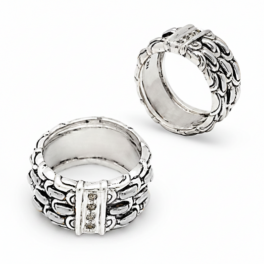 Anello Naga Topaz Collezione Sisik Naga Balinesia, due viste su sfondo bianco, fascia larga con tre file di scaglie artigianali e barra centrale con topazi bianchi naturali in argento 925