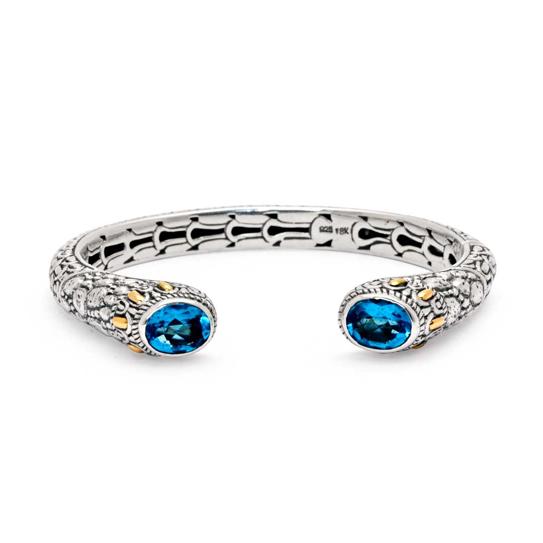 Bangle Naga Quarzo Blu Collezione Sisik Naga Balinesia, vista frontale su sfondo bianco, due quarzi blu ovali ai terminali e accenti oro