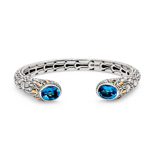 Bangle Naga Quarzo Blu Collezione Sisik Naga Balinesia, vista frontale su sfondo bianco, due quarzi blu ovali ai terminali e accenti oro