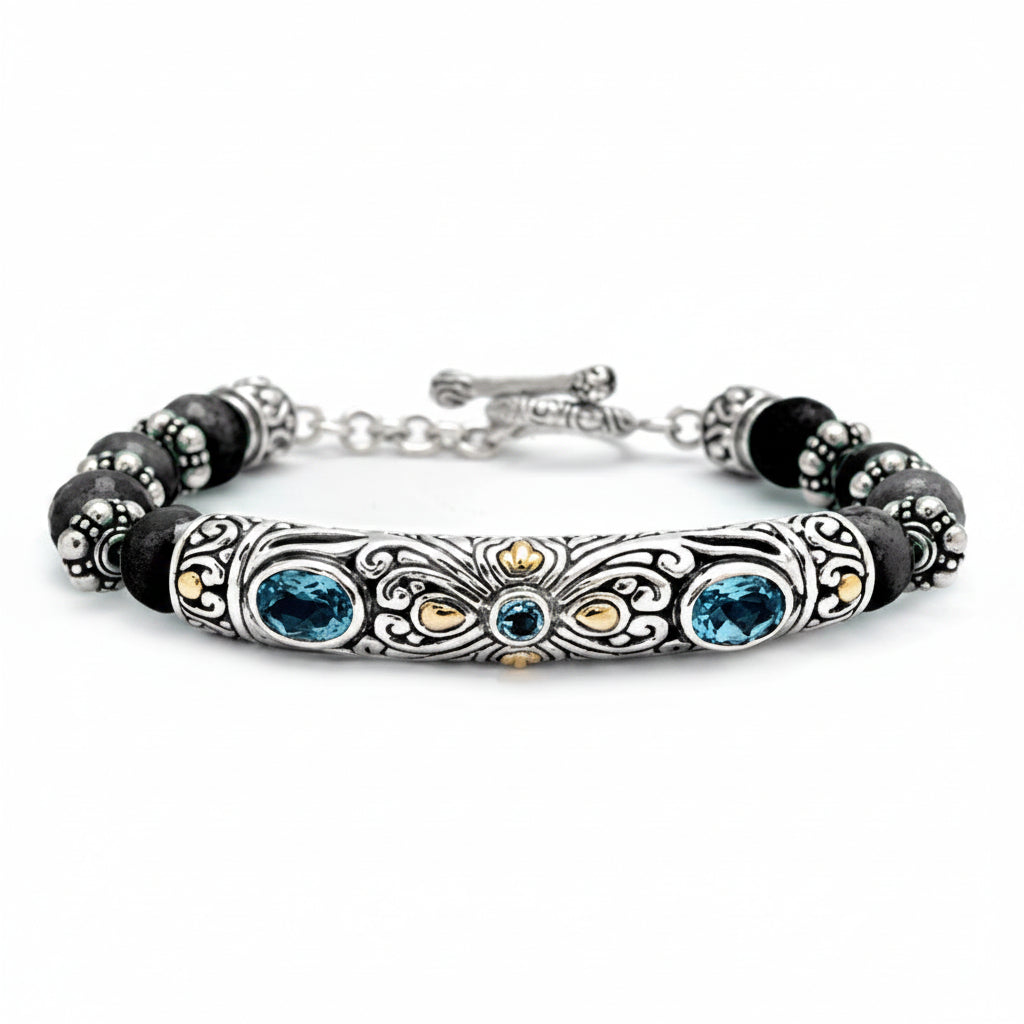 Bracciale Naga in argento 925 con barra a filigrana balinese, topazio blu London, accenti in oro 18K e perle di onice nero — vista frontale su sfondo bianco, Collezione Viaggio a Celuk, Balinesia
