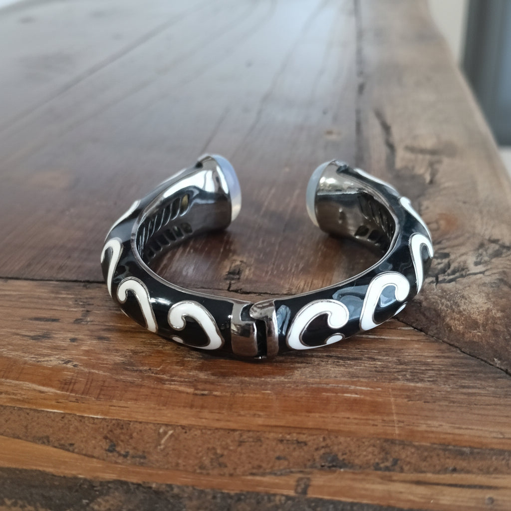 Bracciale Laut Hitam Balinesia – vista posteriore su legno con motivo a onde bianche e interno traforato