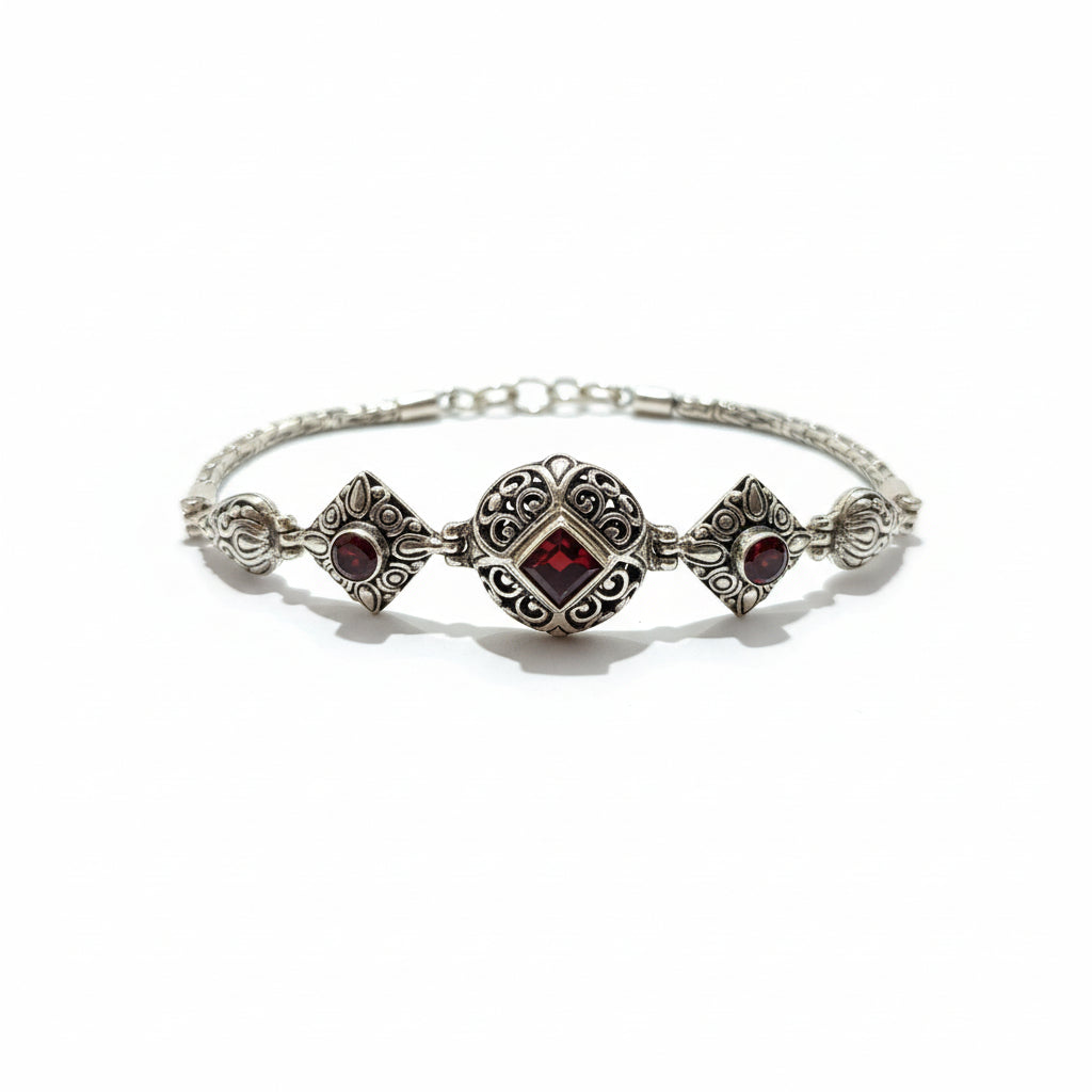Bracciale Pati in argento 925 ossidato con granato naturale taglio princess al centro e due granati cabochon laterali – motivo a filigrana con arabeschi, chiusura a moschettone – Balinesia, Collezione Viaggio a Celuk