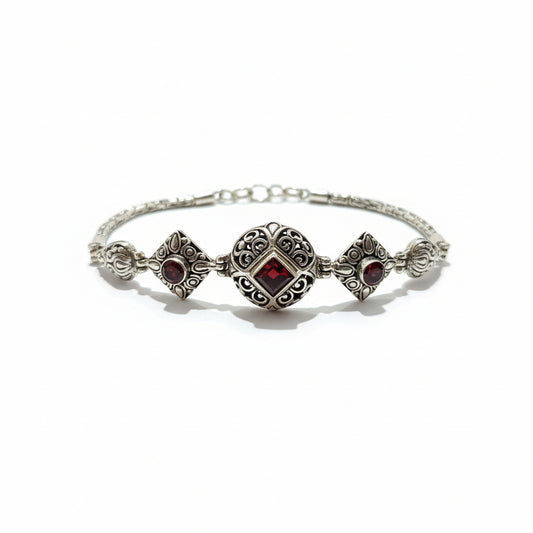 Bracciale Pati in argento 925 ossidato con granato naturale taglio princess al centro e due granati cabochon laterali – motivo a filigrana con arabeschi, chiusura a moschettone – Balinesia, Collezione Viaggio a Celuk