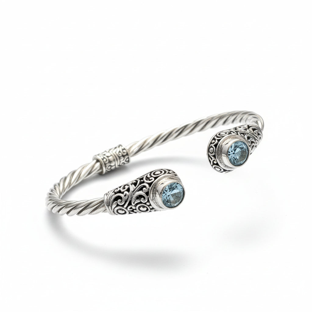 Bracciale Mata Air in argento 925 ossidato con corpo a torchon ritorto e due topazi azzurri naturali a castone con filigrana a volute – bangle aperto, Balinesia, Collezione Viaggio a Celuk