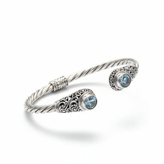 Bracciale Mata Air in argento 925 ossidato con corpo a torchon ritorto e due topazi azzurri naturali a castone con filigrana a volute – bangle aperto, Balinesia, Collezione Viaggio a Celuk