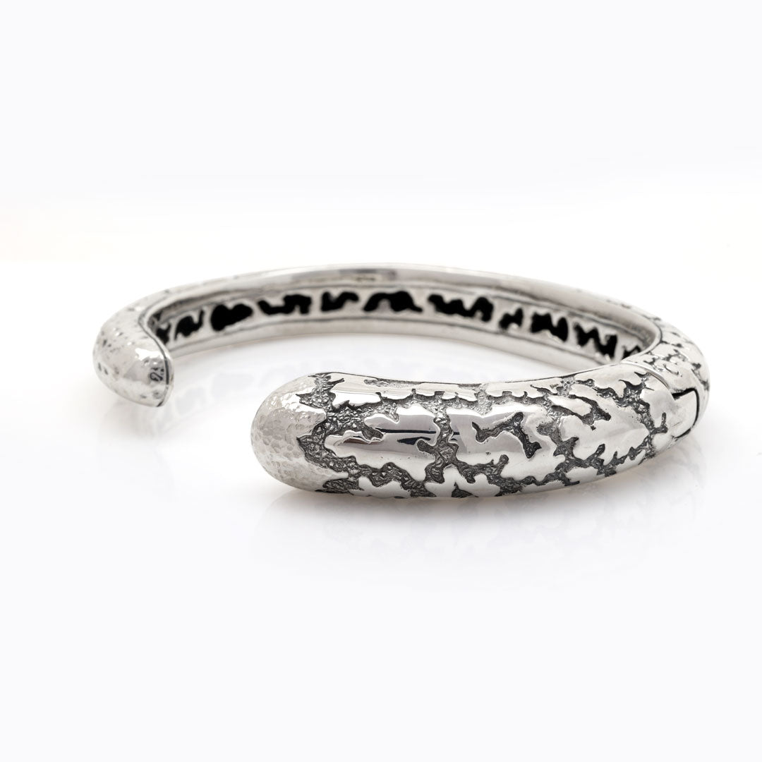 Vista laterale del bangle Lava Perak in argento 925 – struttura tubolare bombata con incisioni e ossidazione – Balinesia