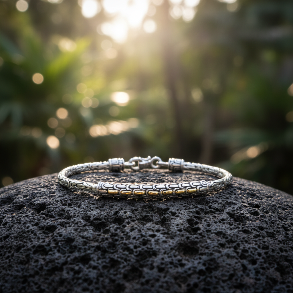 Bracciale Golden Naga Borobudur posato su pietra lavica nella foresta tropicale di Bali, argento 925 e oro 18K con catena Borobudur – Balinesia