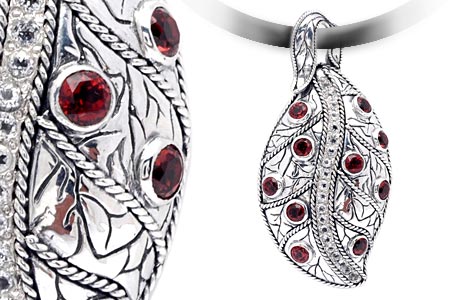 Ciondolo Daun Merah Balinesia, dettaglio macro granati rossi in castone e vista frontale completa con motivi floreali incisi in argento 925 ossidato