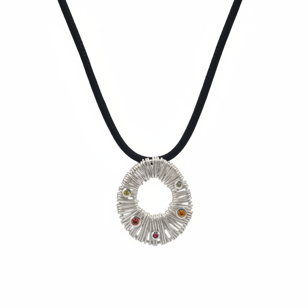 Ciondolo Surya Bali Balinesia su sfondo bianco con cordino nero, ciondolo circolare in argento 925 con texture a raggi e quattro tormaline naturali multicolore incastonate a bezel, Collezione Essenza di Ubud