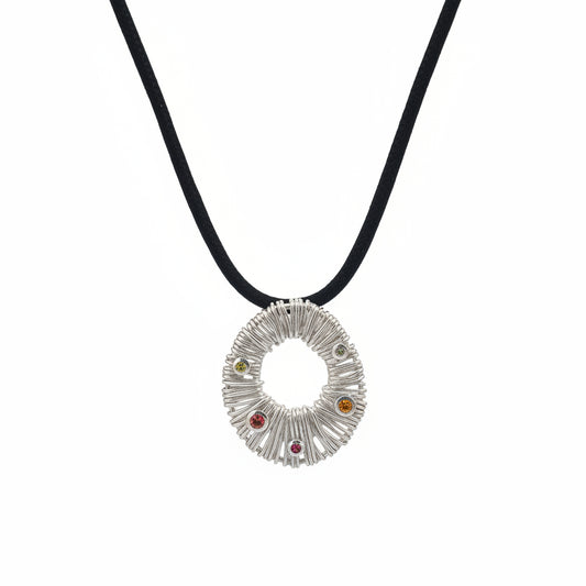 Ciondolo Surya Bali Balinesia su sfondo bianco con cordino nero, ciondolo circolare in argento 925 con texture a raggi e quattro tormaline naturali multicolore incastonate a bezel, Collezione Essenza di Ubud