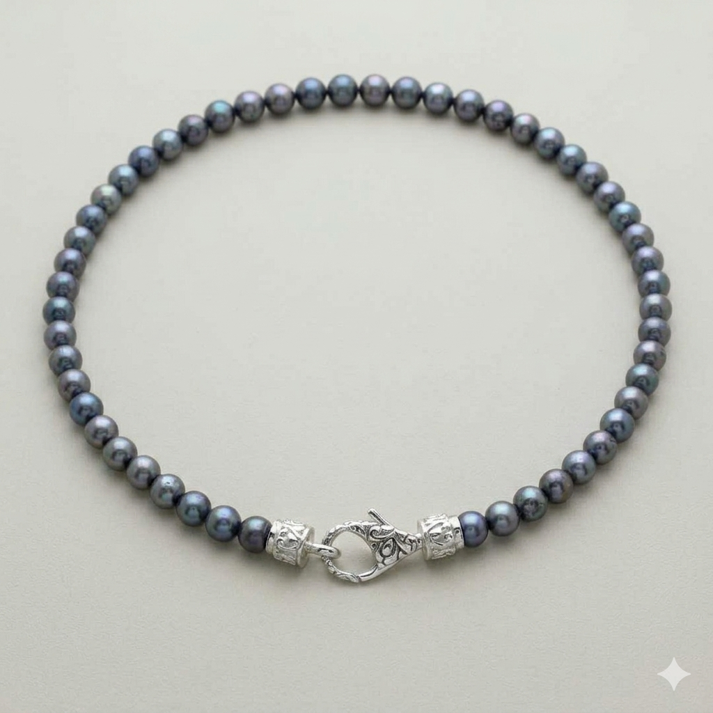 collana Mutiara Kelabu perle d'acqua dolce grigio-blu Balinesia, vista dall'alto su sfondo neutro con chiusura moschettone in argento 925 filigrana balinese