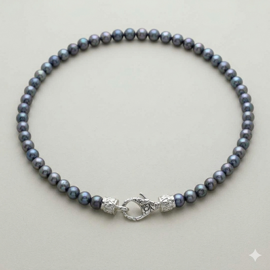 collana Mutiara Kelabu perle d'acqua dolce grigio-blu Balinesia, vista dall'alto su sfondo neutro con chiusura moschettone in argento 925 filigrana balinese