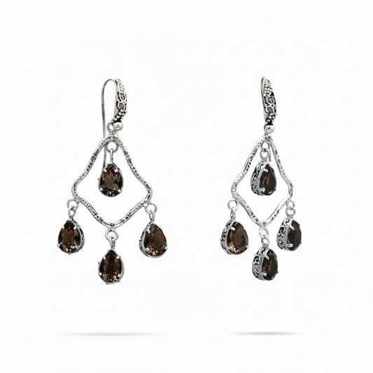 Orecchini Chandelier Quarzo Fumé Balinesia, coppia su sfondo bianco, telaio a rombo in argento 925 ossidato con texture martellata e quattro quarzi fumé naturali pear shape marrone-ambra per orecchino, gancio decorato con volute balinesi, Collezione Essenza di Ubud