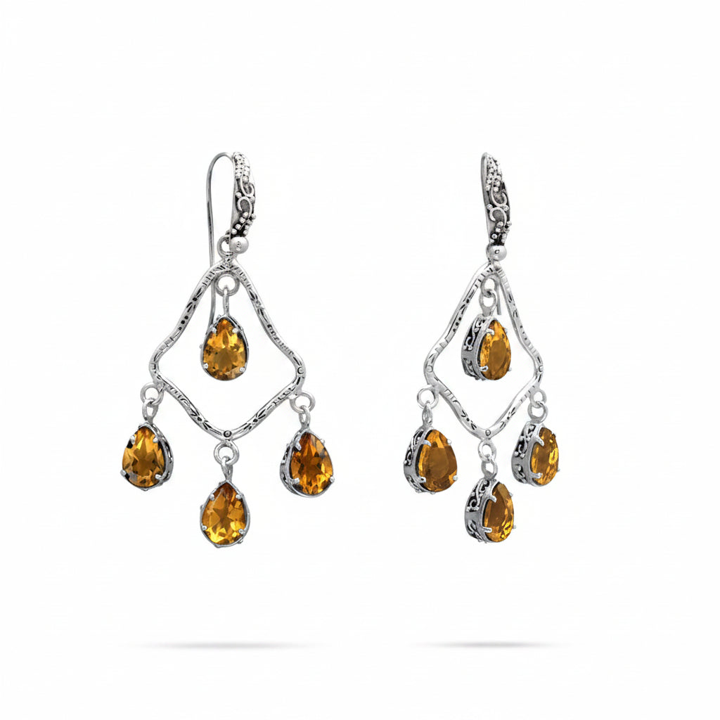 Orecchini Chandelier Citrino Balinesia, coppia su sfondo bianco, struttura a rombo in argento 925 brunito con incisioni balinesi e quattro citrini naturali pear shape giallo-ambra per orecchino, monachella decorata, Collezione Essenza di Ubud