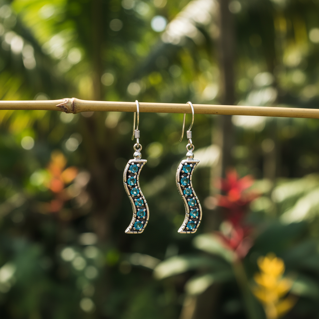 Coppia di Orecchini Buaya Biru appesi a un ramo di bambù in un giardino tropicale balinese, argento 925 ossidato con topazi blu naturali – Balinesia