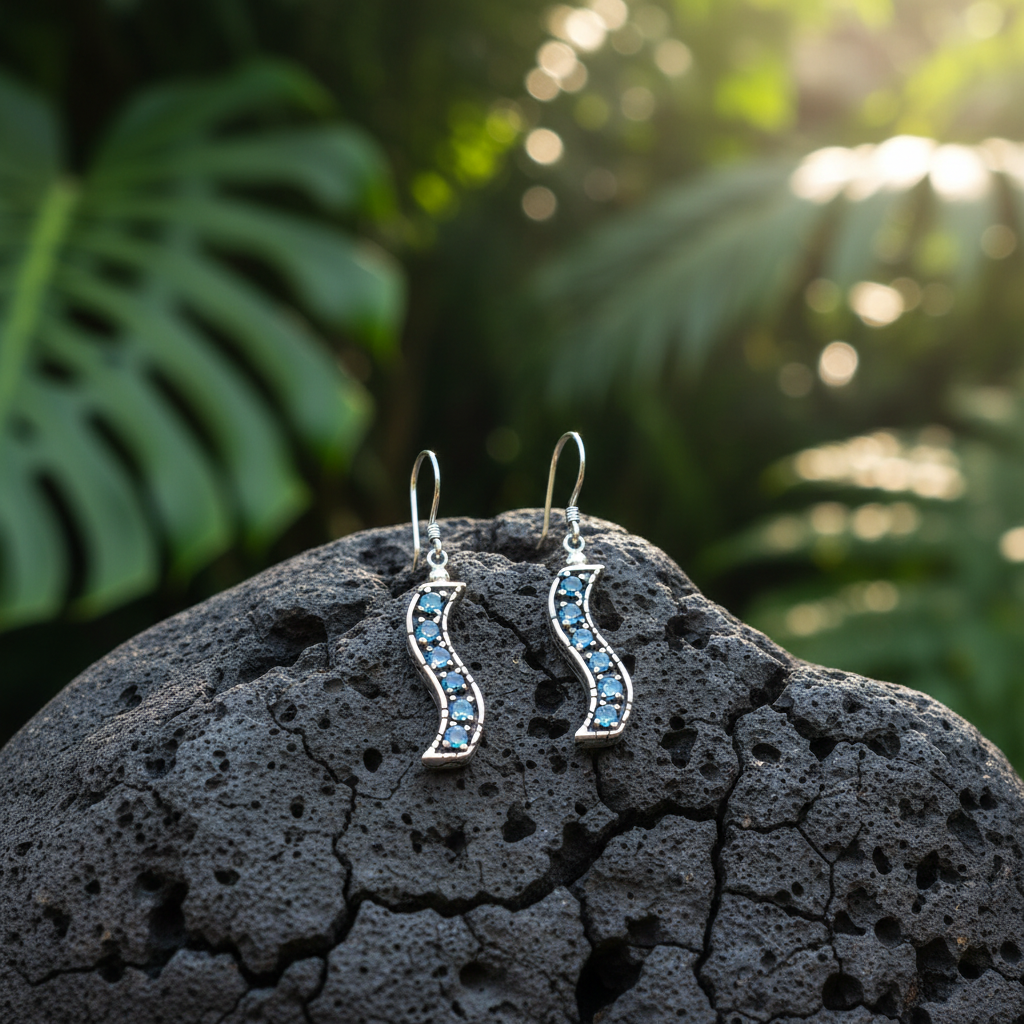 Orecchini Buaya Biru posati su pietra lavica balinese con foglie tropicali, argento 925 ossidato con forma a S e topazi blu naturali in luce naturale – Balinesia
