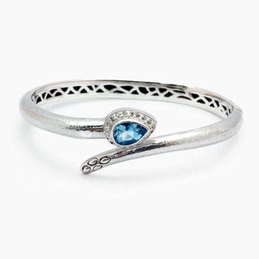 Bangle Black Mamba in argento 925, struttura rigida traforata con topazio blu sky a taglio pera e pavé di zirconi bianchi, coda serpente ossidato – Balinesia